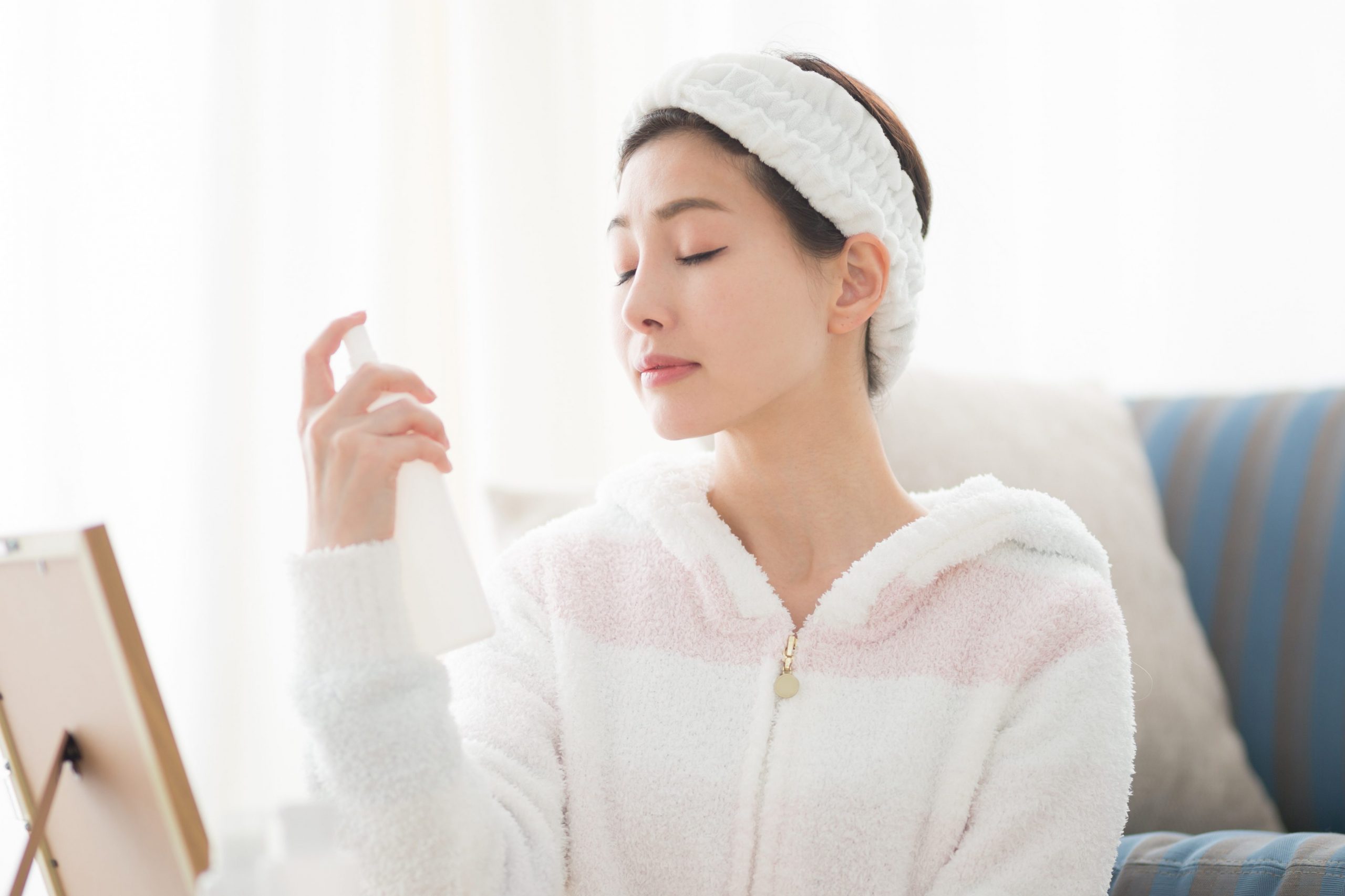顔にミストを当てる女性