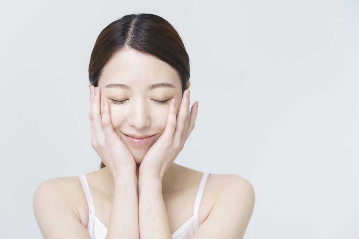 顔に両手を当てる女性