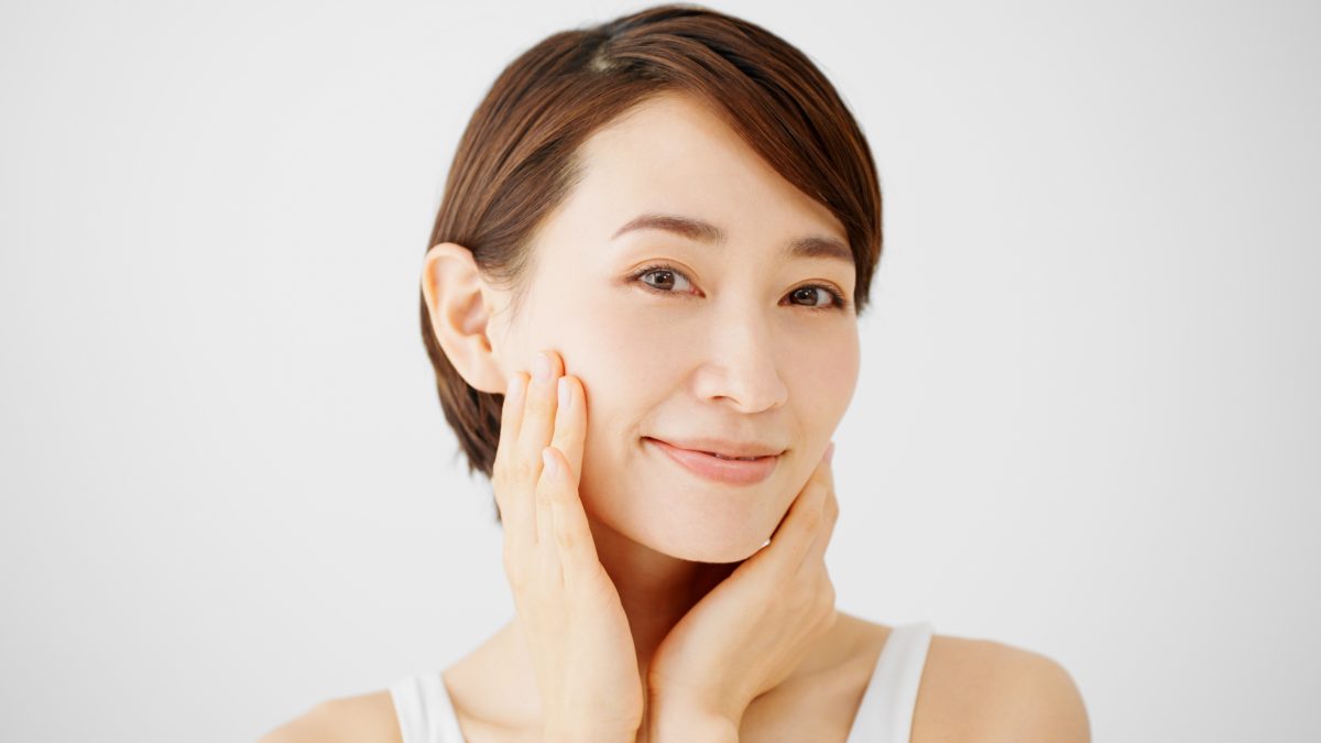 顔に手を当てる女性